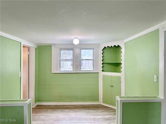 spare room featuring light hardwood / wood-style flooring and ornamental molding