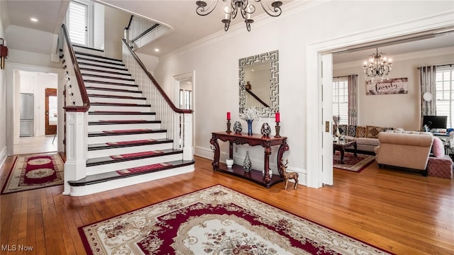 interior space with hardwood / wood-style flooring, an inviting chandelier, and crown molding