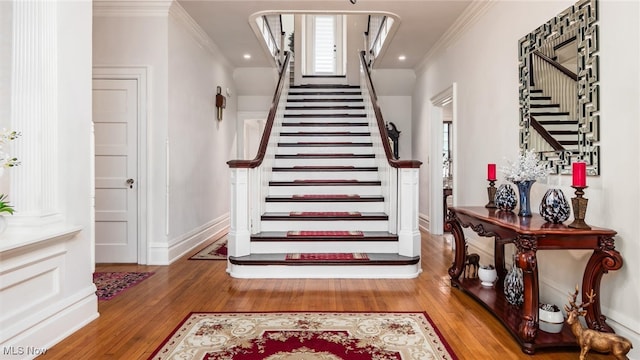 stairway with hardwood / wood-style floors and crown molding