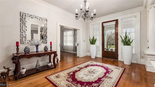 foyer entrance featuring a chandelier, crown molding, and wood-type flooring