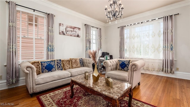 living room with hardwood / wood-style floors, a notable chandelier, and crown molding