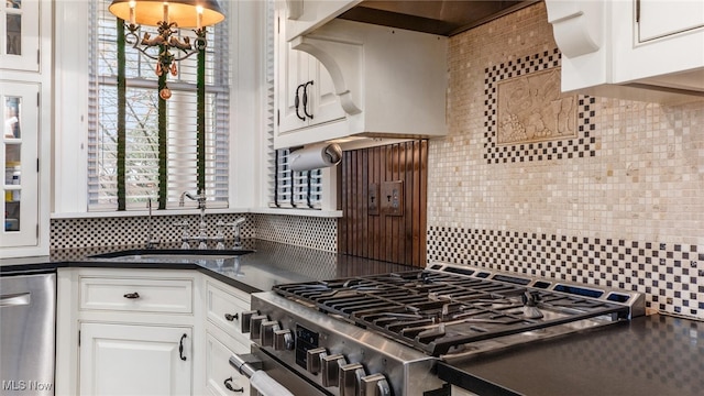 kitchen featuring pendant lighting, white cabinets, sink, decorative backsplash, and stainless steel appliances