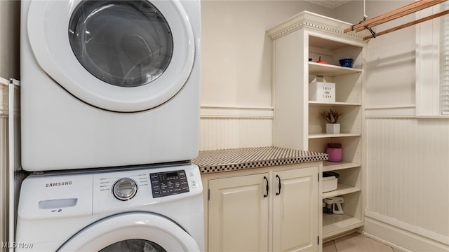 washroom featuring stacked washer / dryer and light tile patterned flooring