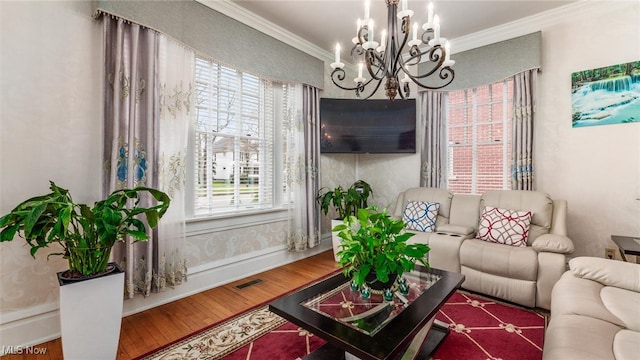 living room featuring hardwood / wood-style floors, crown molding, and a notable chandelier