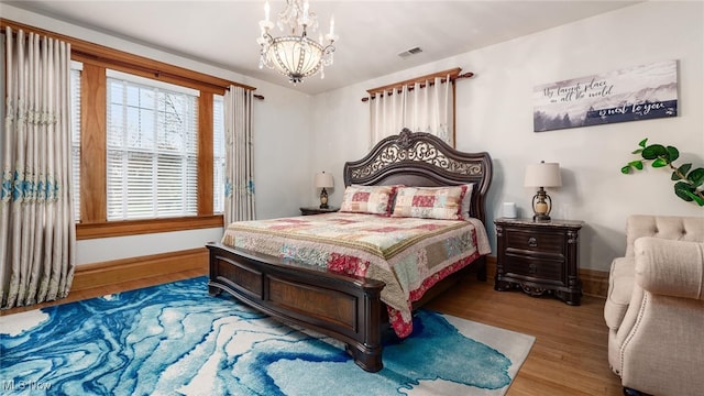 bedroom with a notable chandelier and hardwood / wood-style flooring