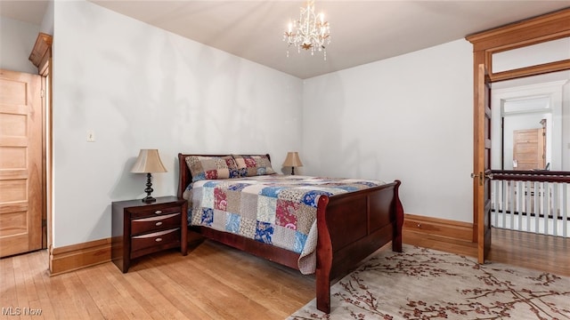 bedroom featuring a chandelier and light hardwood / wood-style flooring