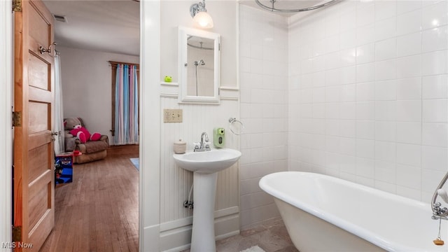 bathroom featuring a bath, wood-type flooring, and sink