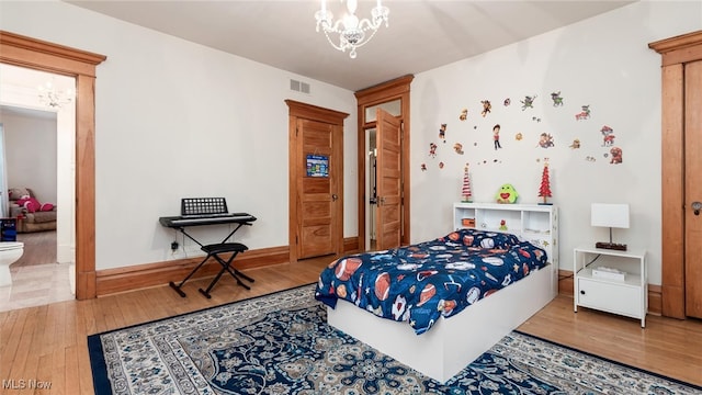 bedroom featuring a notable chandelier and wood-type flooring