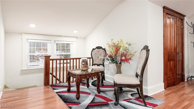 living area featuring light hardwood / wood-style flooring and vaulted ceiling