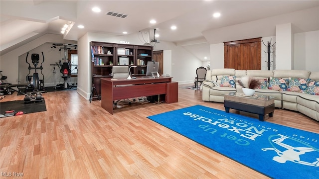 exercise room with light hardwood / wood-style floors