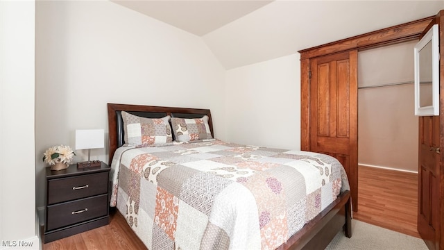 bedroom featuring light hardwood / wood-style floors and vaulted ceiling