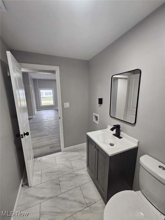 bathroom with hardwood / wood-style floors, vanity, and toilet