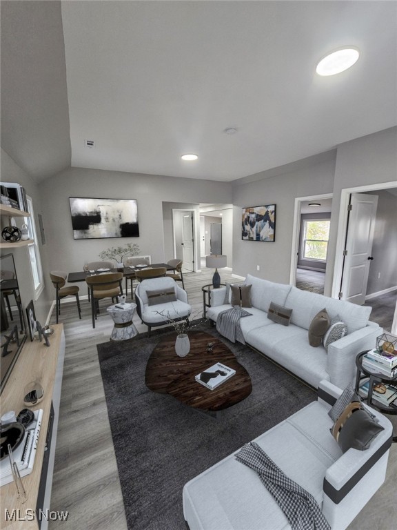 living room with hardwood / wood-style flooring and vaulted ceiling