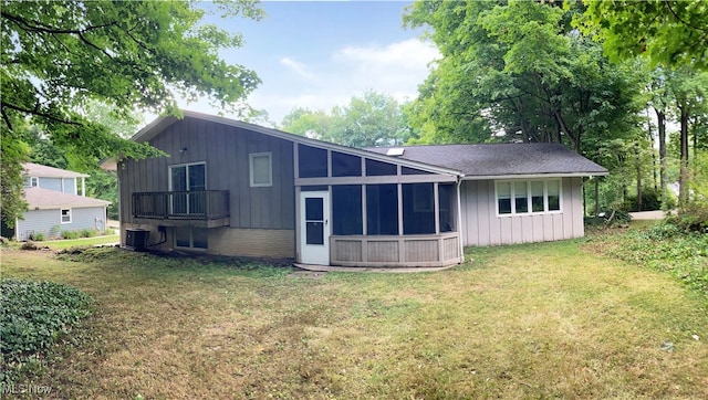 back of house featuring a sunroom, central air condition unit, and a lawn