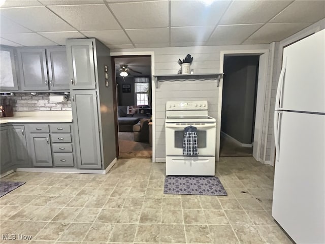 kitchen featuring white appliances, tasteful backsplash, a drop ceiling, and gray cabinetry