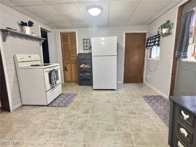 kitchen featuring light tile patterned floors, white appliances, and a drop ceiling