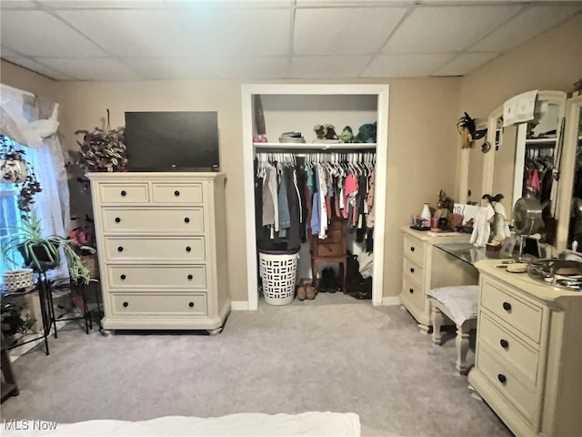 bedroom featuring a paneled ceiling, light carpet, and a closet