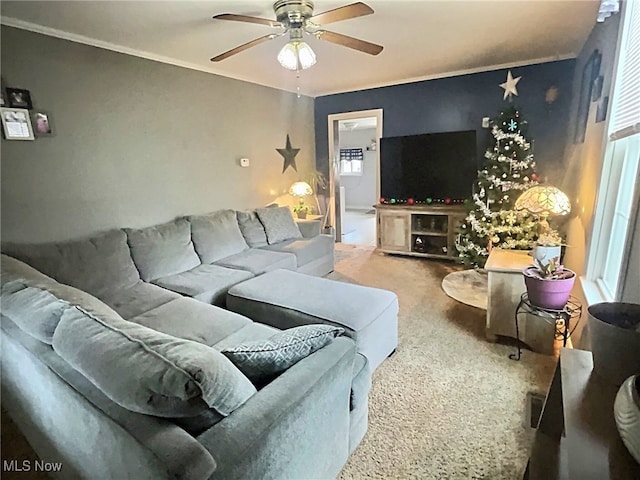 carpeted living room with ceiling fan, a healthy amount of sunlight, and ornamental molding