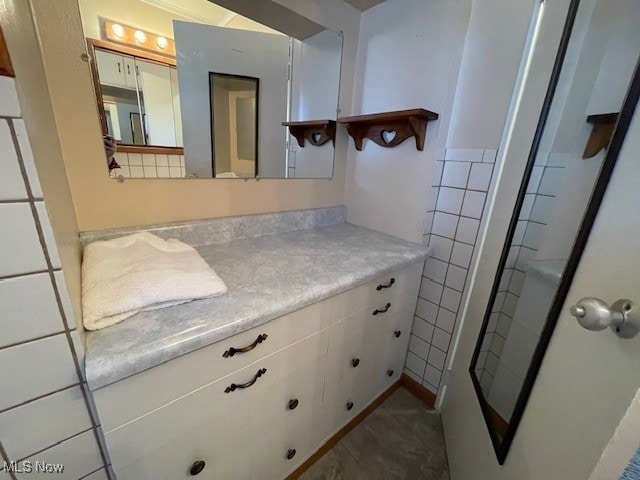 bathroom with vanity and tile walls