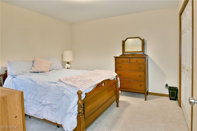 bedroom featuring light colored carpet and a closet