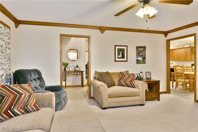 carpeted living room with ceiling fan and ornamental molding