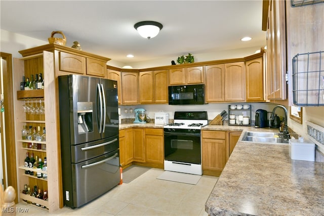 kitchen featuring stainless steel fridge, white gas stove, light tile patterned floors, and sink