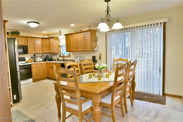 tiled dining room with an inviting chandelier and sink