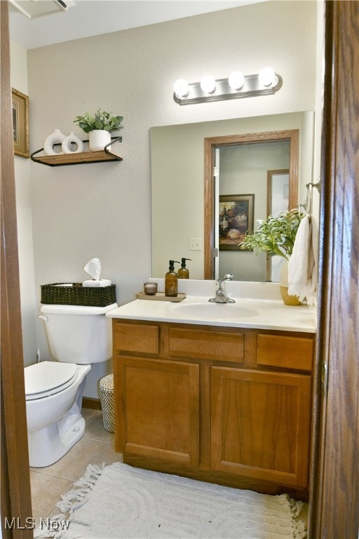 bathroom with tile patterned flooring, vanity, and toilet