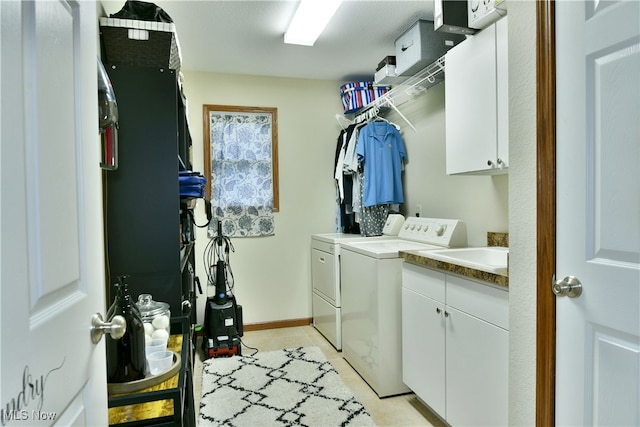 clothes washing area featuring cabinets, independent washer and dryer, sink, and light tile patterned floors