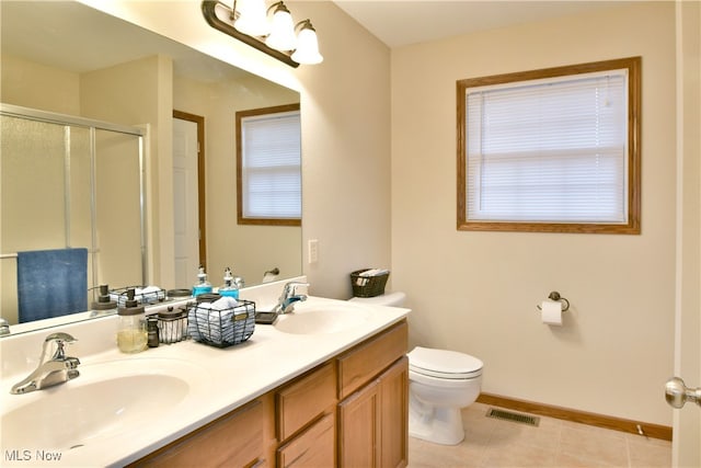 bathroom with tile patterned flooring, vanity, toilet, and a shower with shower door