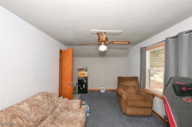 living room featuring ceiling fan, dark carpet, and lofted ceiling