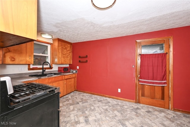 kitchen with a textured ceiling, black range with electric cooktop, and sink