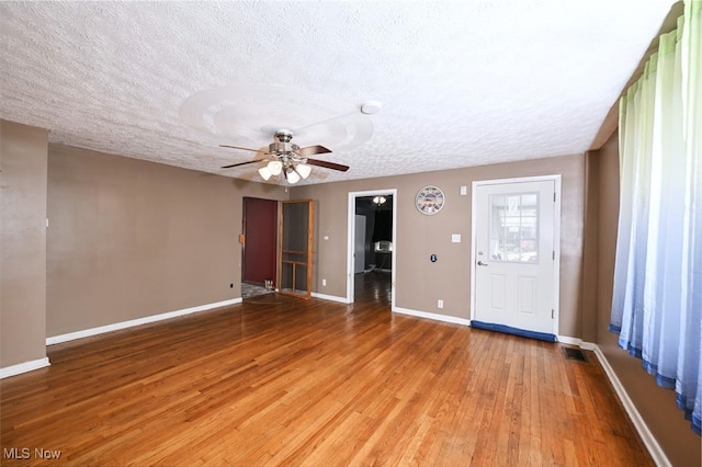 interior space with ceiling fan, wood-type flooring, and a textured ceiling