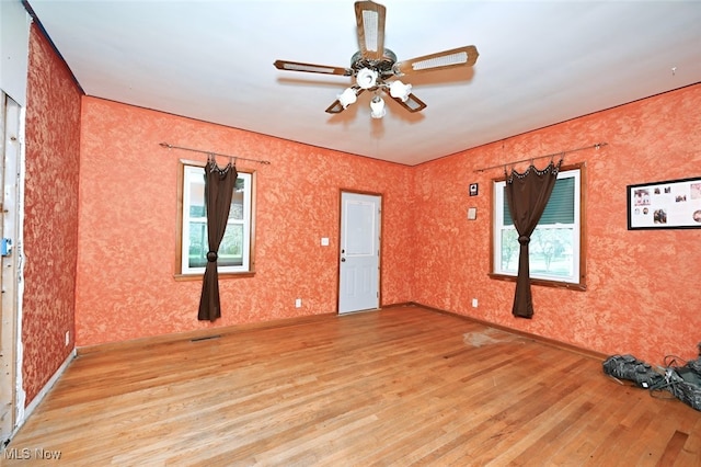 empty room with ceiling fan and light hardwood / wood-style floors