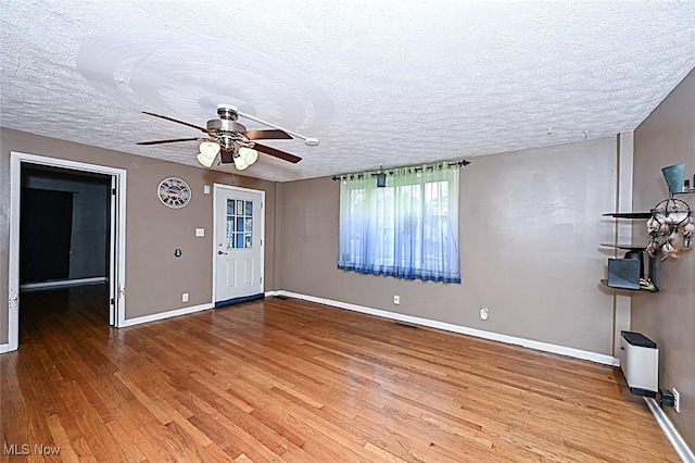 entryway with a textured ceiling, hardwood / wood-style flooring, and ceiling fan