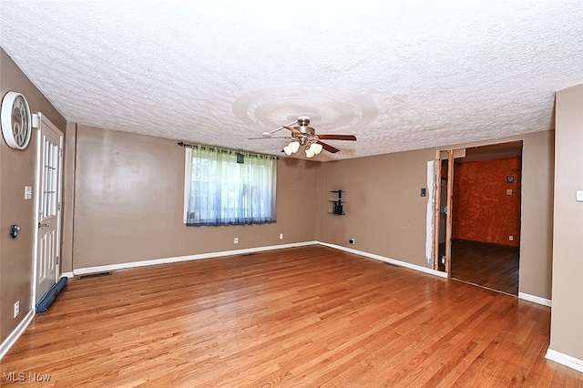 spare room featuring a textured ceiling, hardwood / wood-style flooring, and ceiling fan