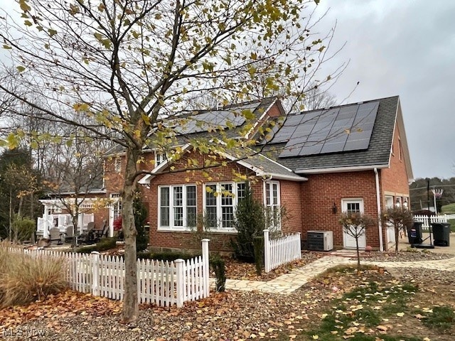 exterior space featuring solar panels and central air condition unit