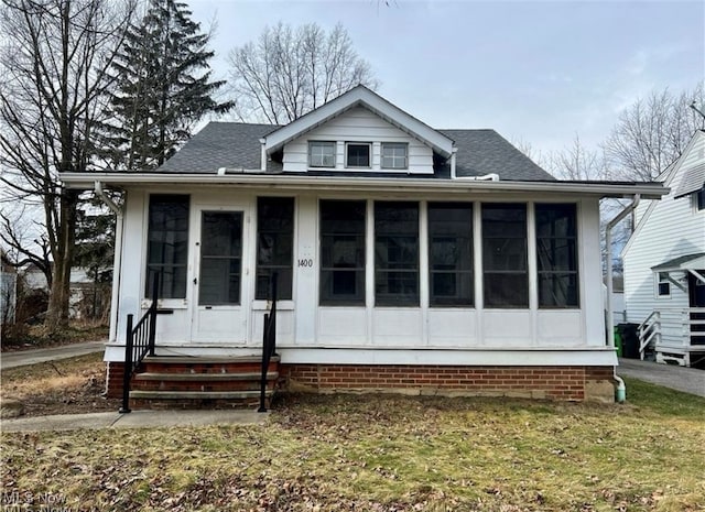 view of front of home featuring a sunroom and a front yard