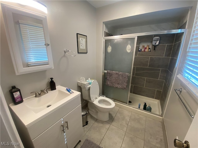 bathroom featuring tile patterned floors, toilet, vanity, and walk in shower