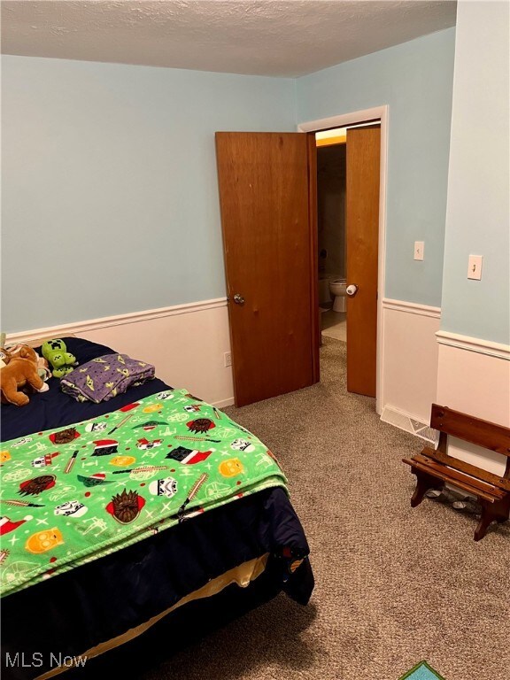 carpeted bedroom featuring a textured ceiling