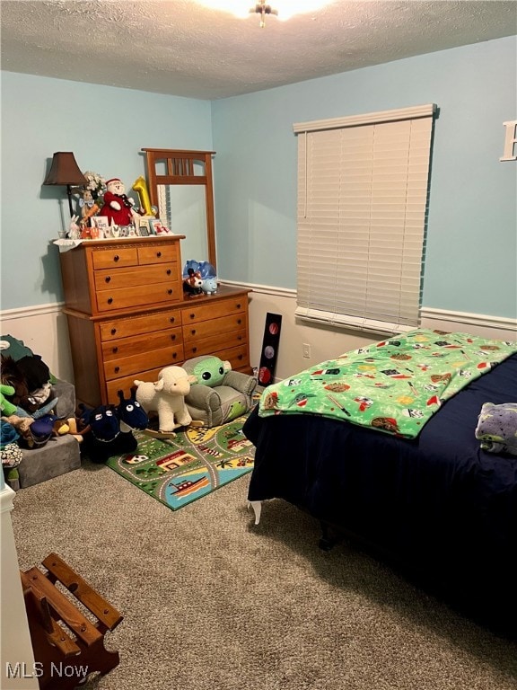 bedroom with carpet floors and a textured ceiling