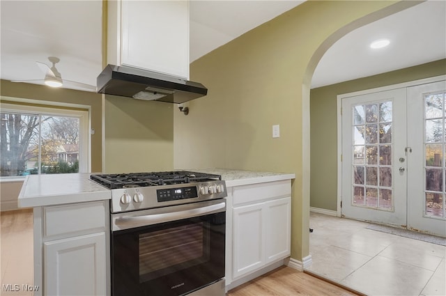 kitchen with white cabinets, a wealth of natural light, and stainless steel range with gas stovetop