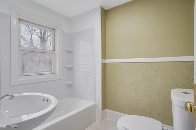 bathroom featuring tile patterned flooring, toilet, and a bath