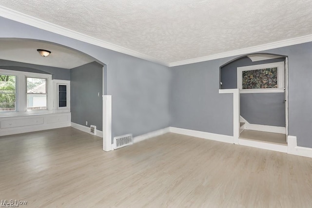 unfurnished room with a textured ceiling, hardwood / wood-style flooring, and ornamental molding