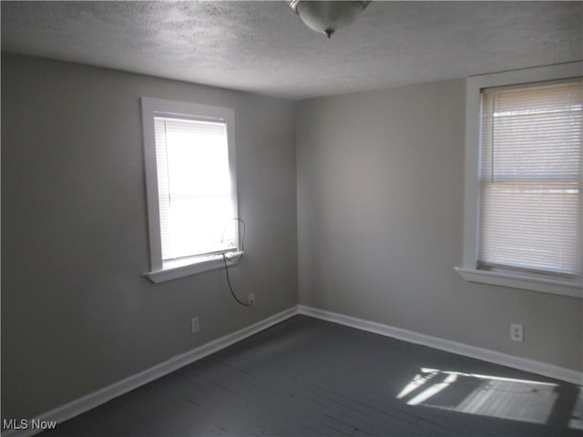 empty room with a textured ceiling and hardwood / wood-style flooring