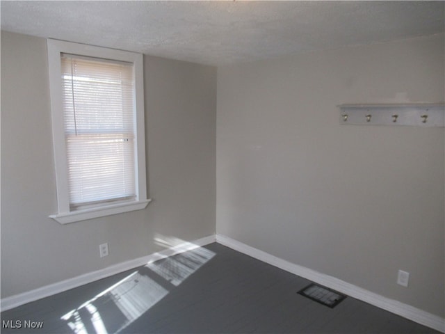 unfurnished room featuring a textured ceiling