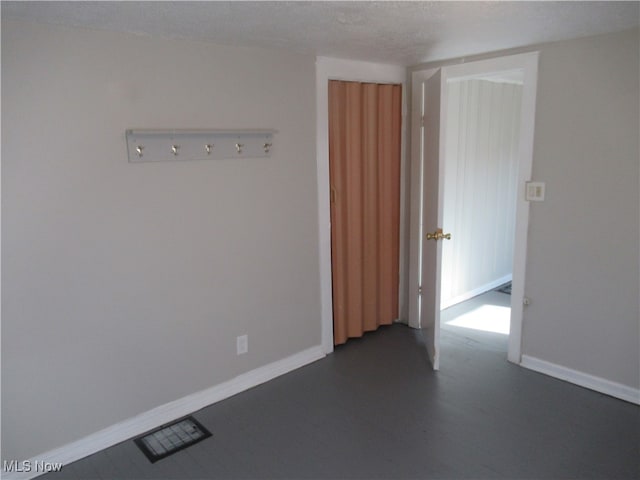 unfurnished room featuring a textured ceiling