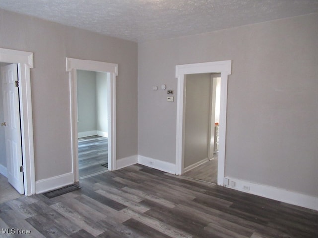 empty room featuring dark hardwood / wood-style flooring and a textured ceiling