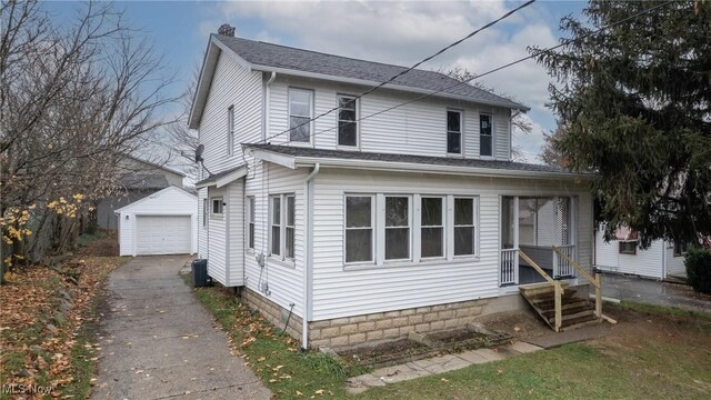 view of front of home featuring central air condition unit, an outbuilding, and a garage