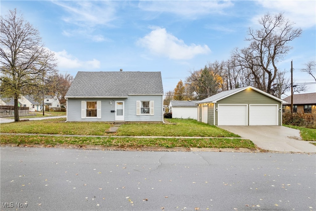 view of front facade with a front yard, a garage, and an outdoor structure